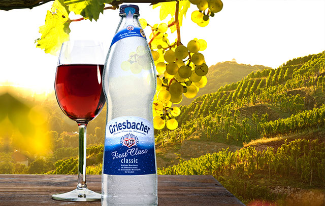 Griesbacher Mineralwasserflasche und ein Glas Rotwein
